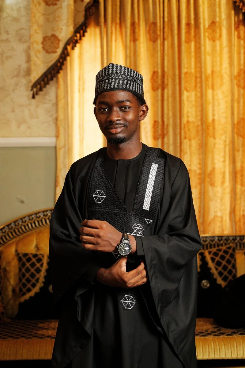 Real Hausa man in Abuja wearing a black kaftan and flowing baban riga with a patterned Hausa cap